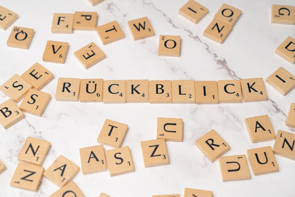 Scrabble tiles spelling 'Rückblick' on marble surface, symbolizing nostalgia.